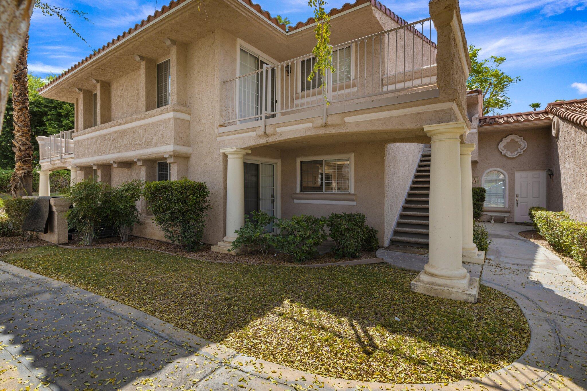 505 South Farrell Drive, Unit A3 Palm Springs, CA 92264 - Photo 35 of 43 a view of a white house with large windows and a lawn chairs and a yard