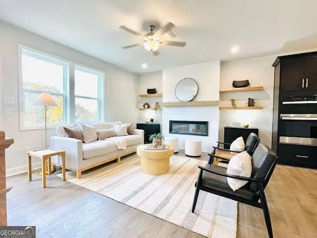 a living room with furniture a fireplace and a large window