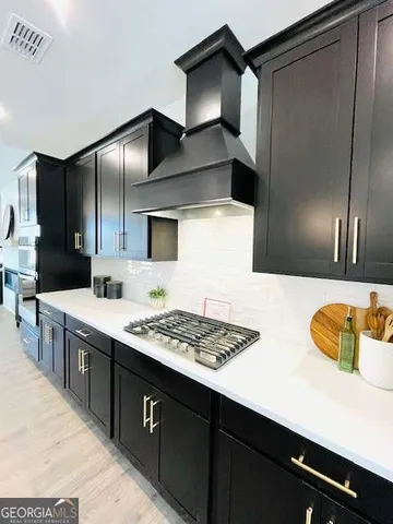 a kitchen with stainless steel appliances kitchen island granite countertop a sink dishwasher stove and refrigerator with wooden floor