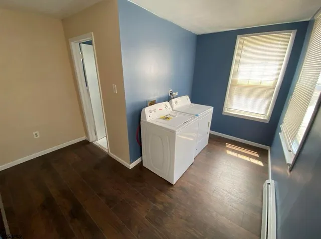 a utility room with wooden floor washer and dryer