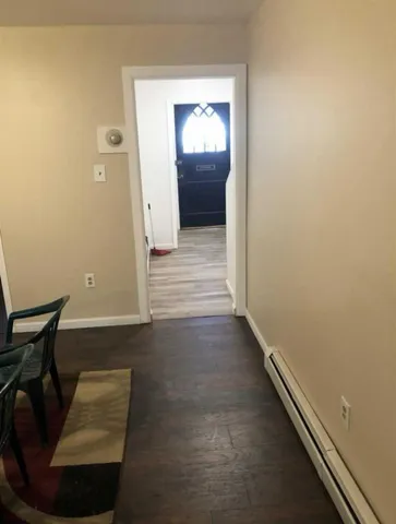 a view of an empty room with wooden floor and closet