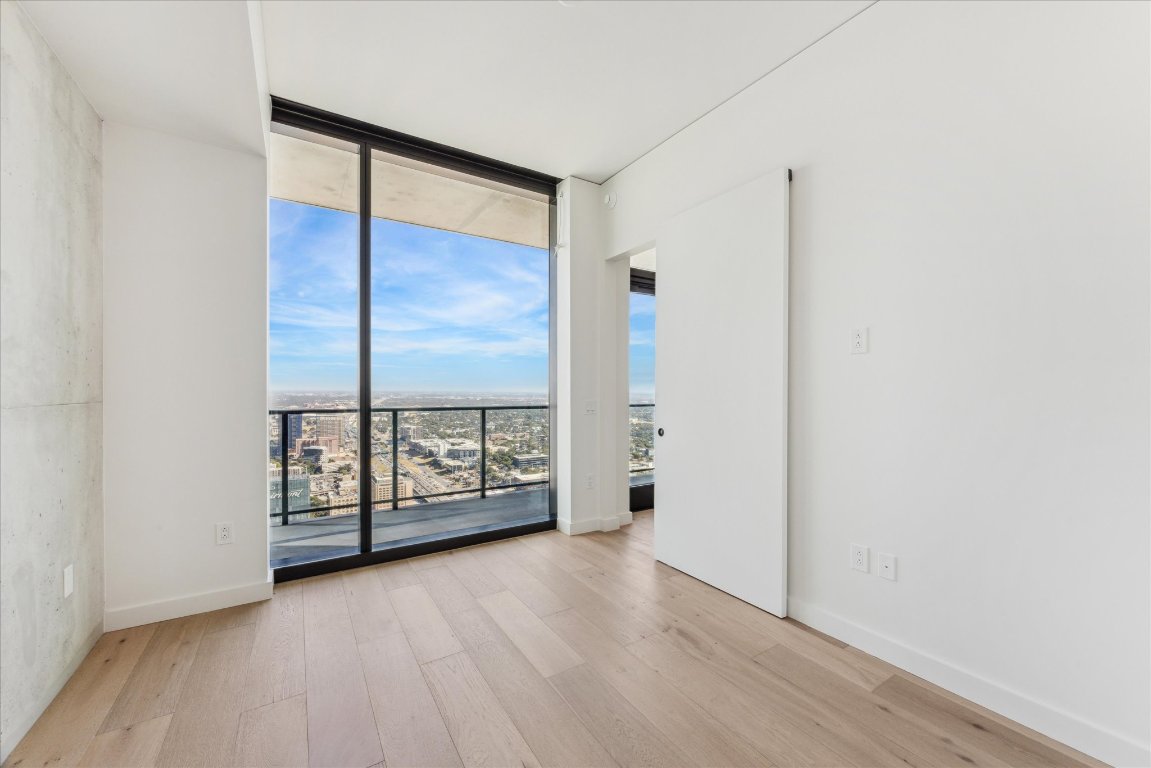 610 Davis Street, Unit 5006 Austin, TX 78701 - Photo 8 of 40 an empty room with sliding door and wooden floor