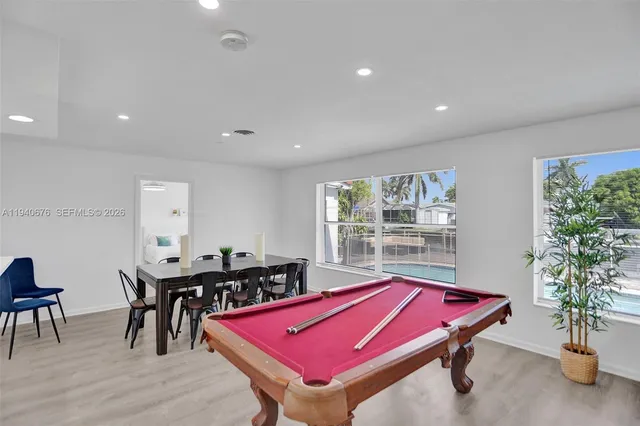 a room with furniture pool table and windows