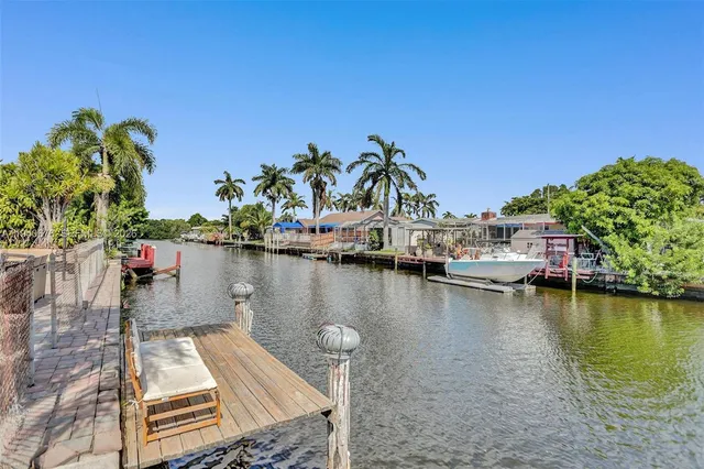 a view of a lake with boats and palm trees