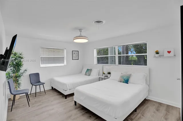 a bedroom with two beds and a potted plant