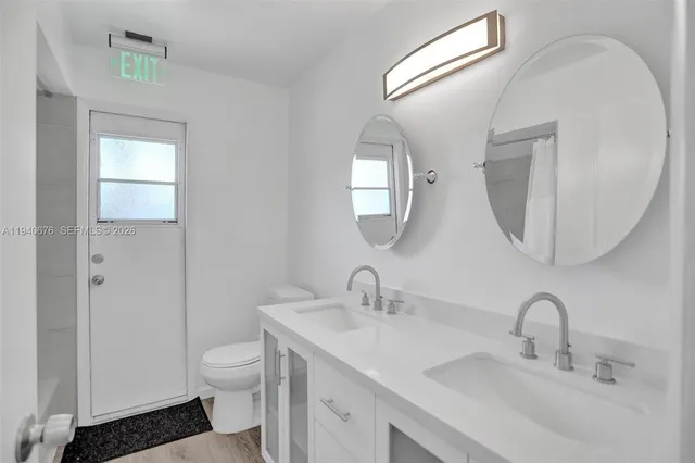 a bathroom with a toilet sink and mirror