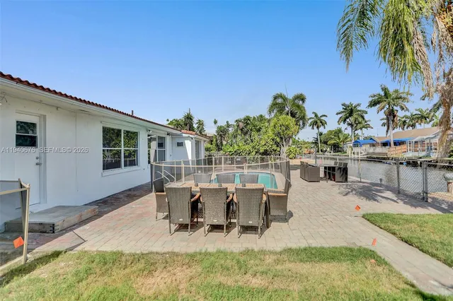 a view of a patio with table and chairs potted plants with wooden floor and fence