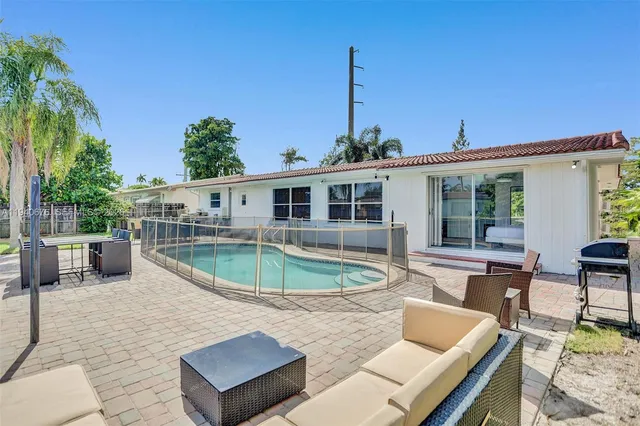 a view of a house with swimming pool and sitting area