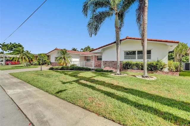 a view of a big house with a big yard and potted plants
