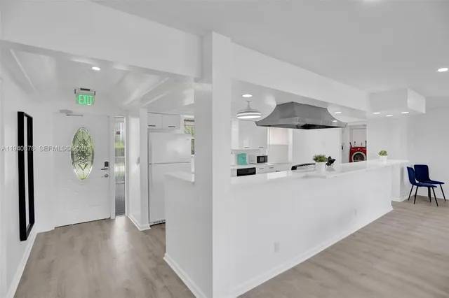 a view of kitchen with stainless steel appliances refrigerator stove microwave and cabinets