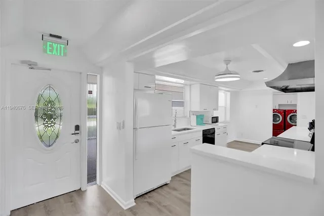 a kitchen view with white cabinets and refrigerator