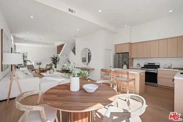 a kitchen with a dining table chairs and stove