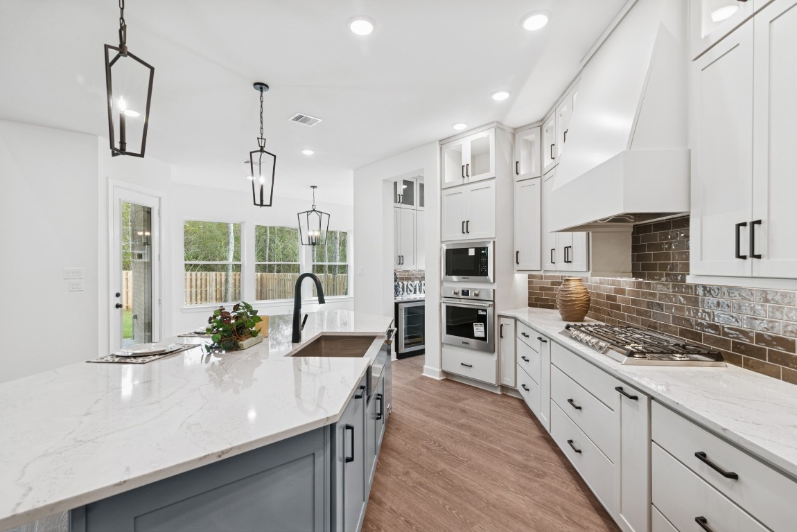 1736 Howler Way Montgomery, TX 77316 - Photo 10 of 48 Quartz counters, double trash drawer, apron front kitchen sink, 36 inch cooktop with updraft vent hood and so much more!