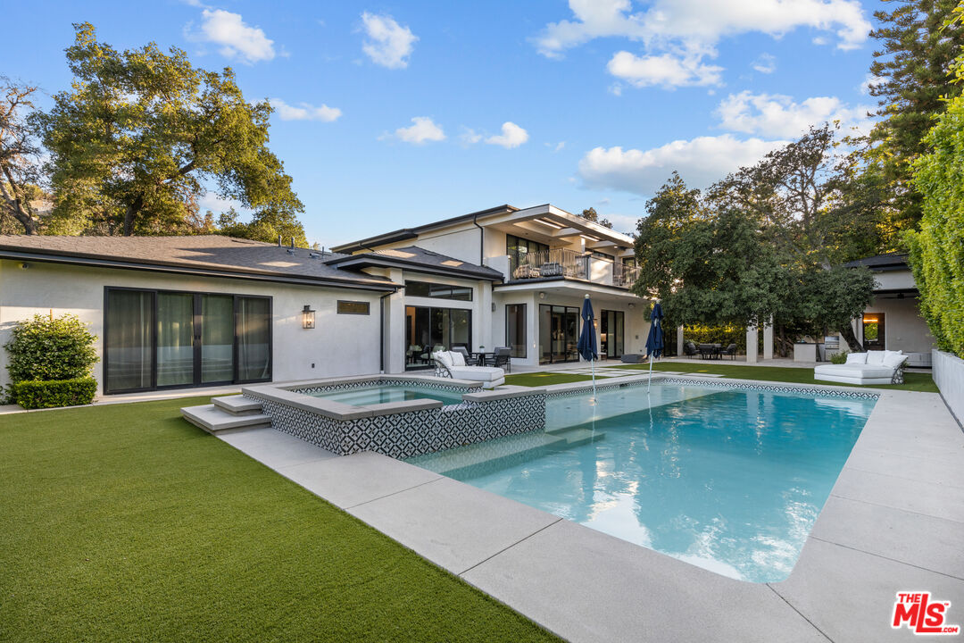 a view of a house with pool table and chairs with wooden fence