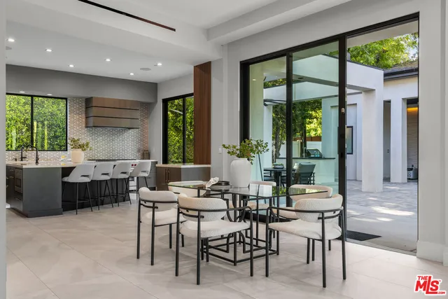 a dining room with furniture a large window and a rug