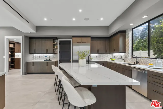 a kitchen with a sink a counter top space stainless steel appliances and cabinets