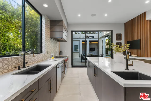 a large kitchen with a large window and stainless steel appliances