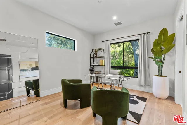 a living room with furniture a floor to ceiling window and wooden floor