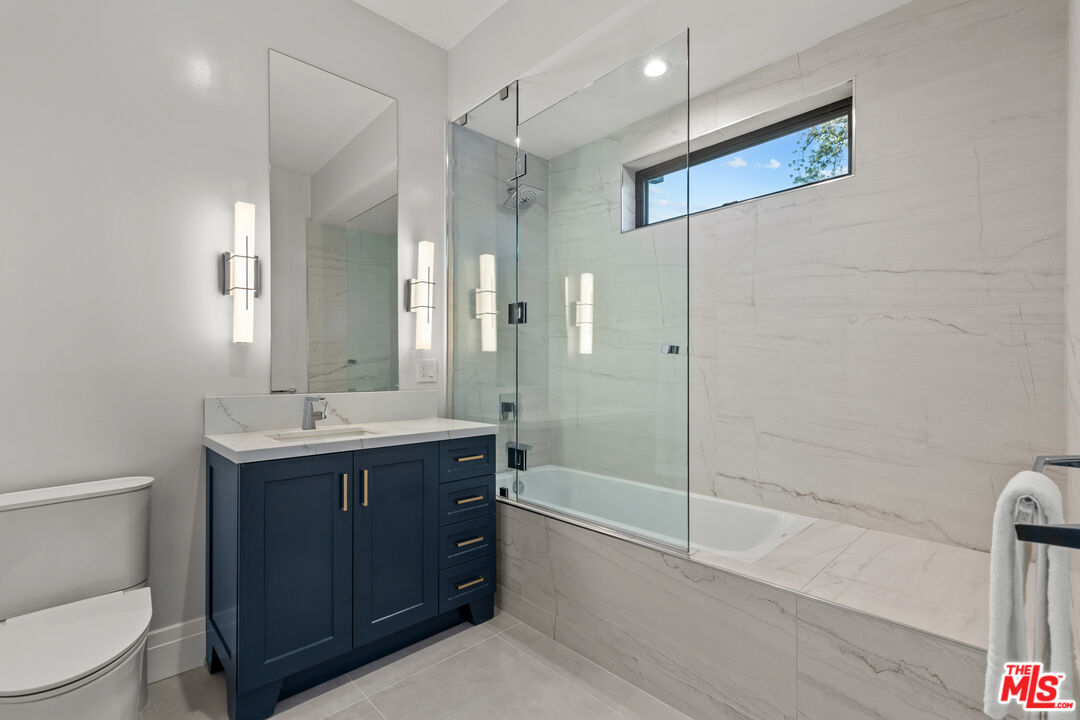 17401 Rancho Street Encino, CA 91316 - Photo 28 of 48 a bathroom with a bathtub shower sink mirror and toilet
