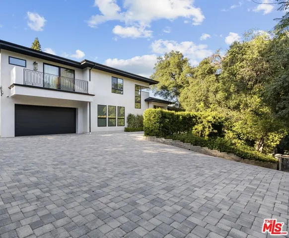 a view of a house with a yard and potted plants