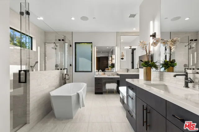 a large bathroom with a double vanity sink a large mirror and a shower