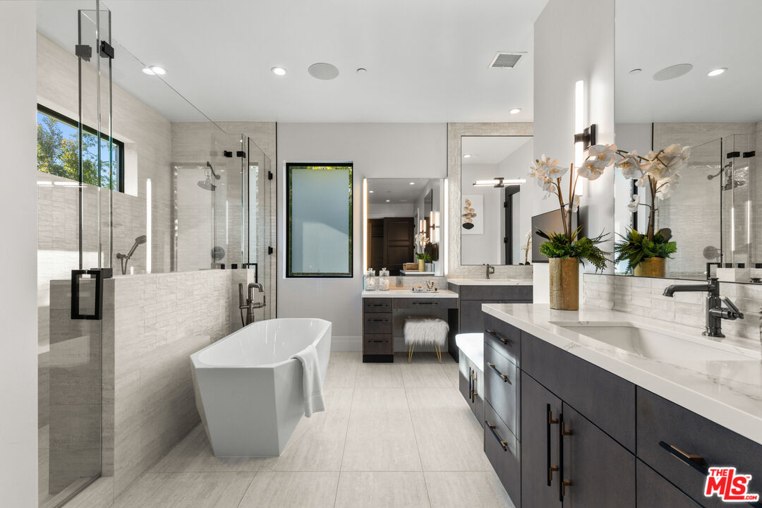 17401 Rancho Street Encino, CA 91316 - Photo 32 of 48 a large bathroom with a double vanity sink a large mirror and a shower