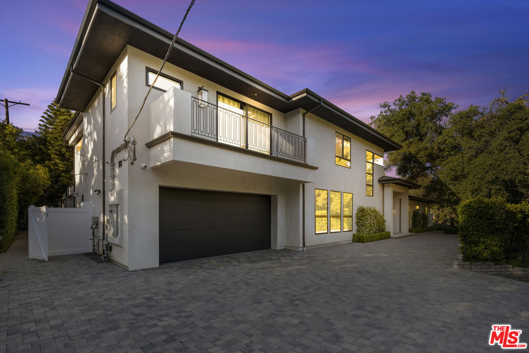 17401 Rancho Street Encino, CA 91316 - Photo 46 of 48 a front view of a house with a yard and garage