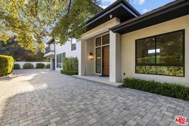 a view of a parking space in a house with a garden