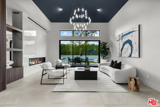a living room with furniture chandelier and a large window