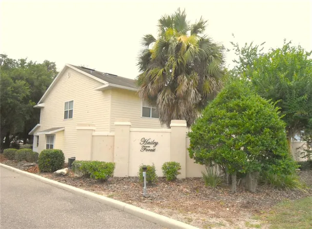 a view of a house with a big yard and large trees