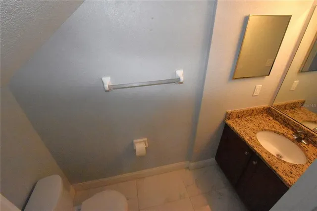 a kitchen with granite countertop a refrigerator and a stove top oven