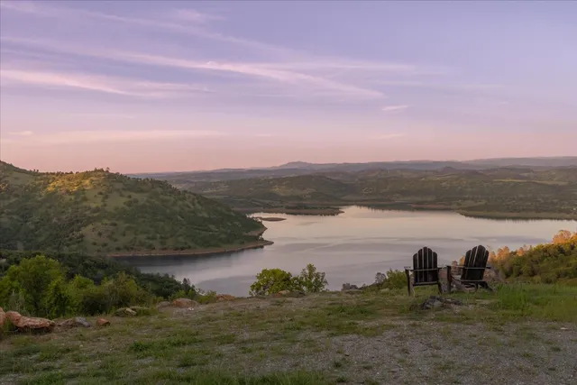 a view of a lake with sunset in background