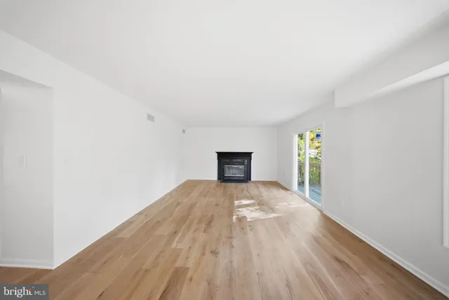 a view of a room with wooden floor and front door