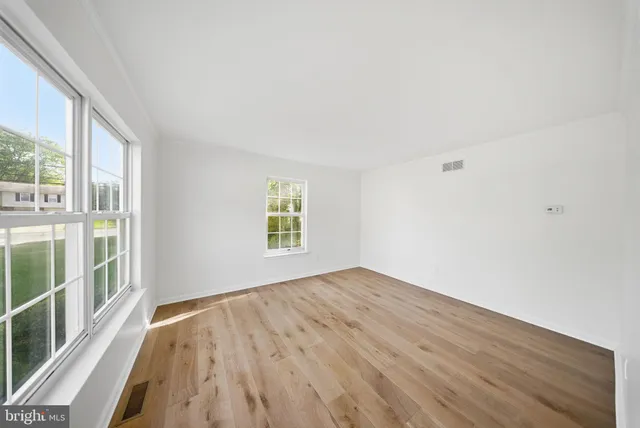 wooden floor in an empty room with a window