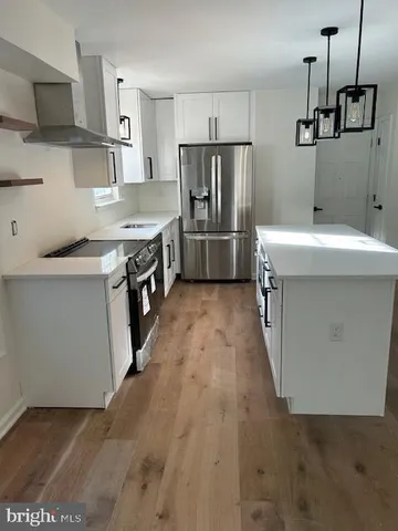 a kitchen with a sink a refrigerator and a stove