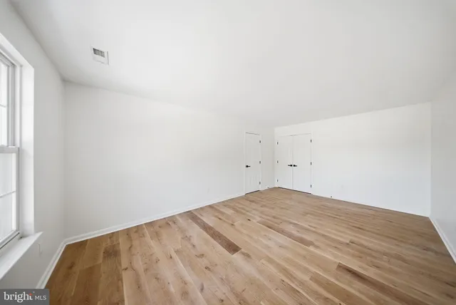 a view of empty room with wooden floor