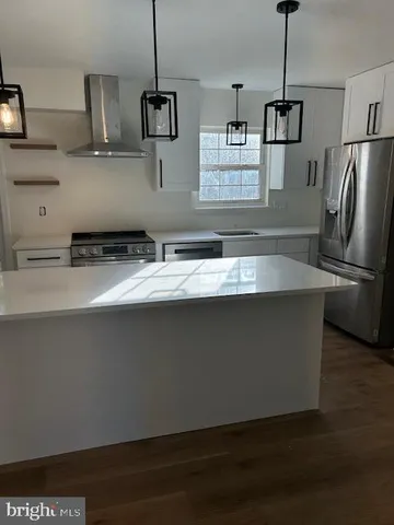 a kitchen with stainless steel appliances granite countertop a sink a stove and a refrigerator