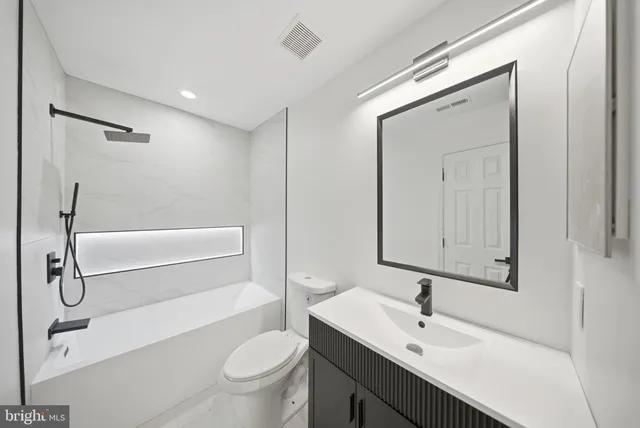 a bathroom with a sink a toilet and a mirror