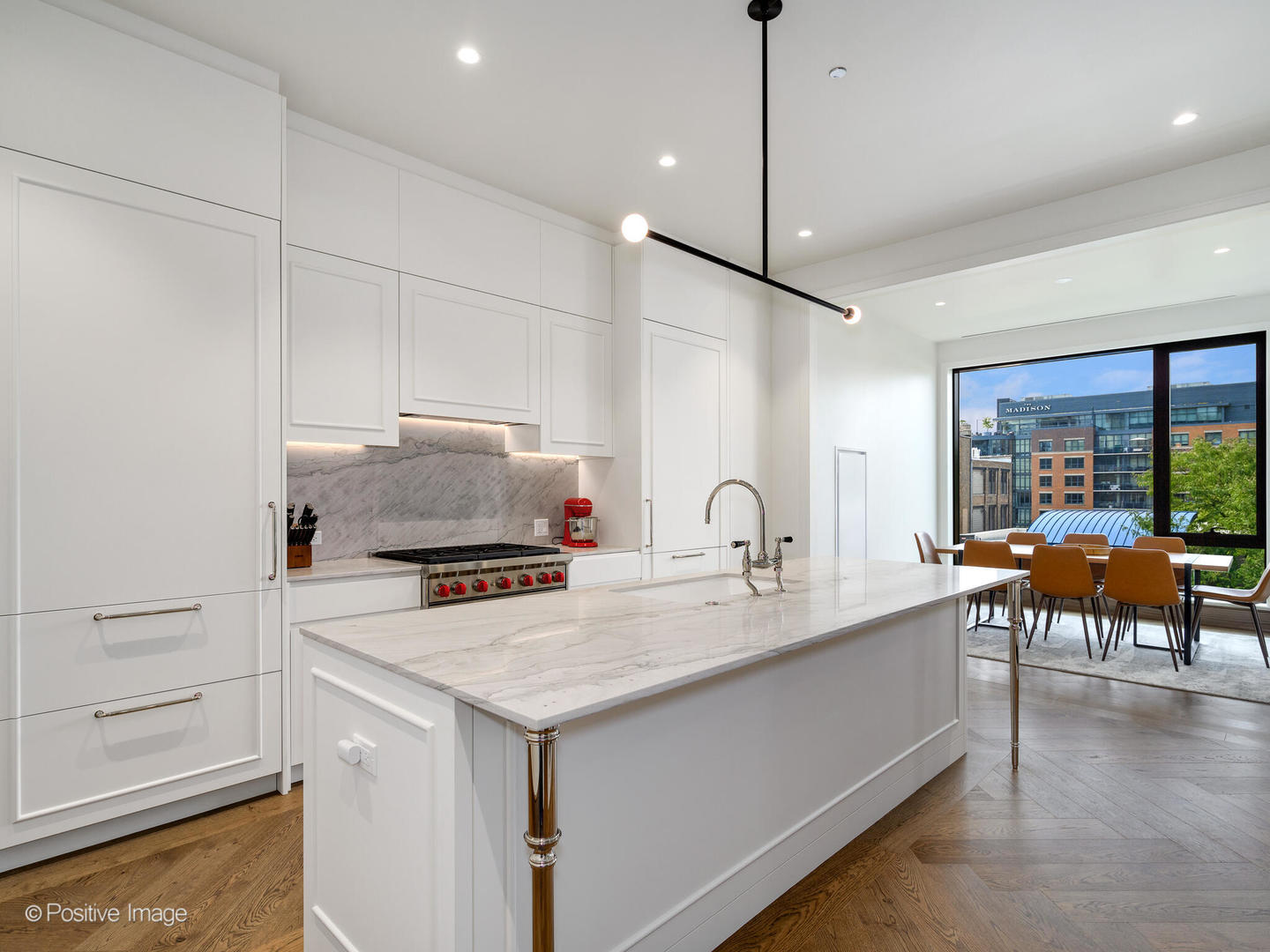 21 North May Street, Unit 505 Chicago, IL 60607 - Photo 12 of 27 a kitchen with a stove a refrigerator and a dining table with wooden floor