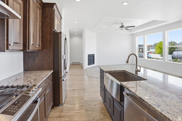 3636 West 910 South Syracuse, UT 84075 - Photo 35 of 70 Kitchen island with granite countertop, stainless steel farmhouse sink, and gooseneck faucet