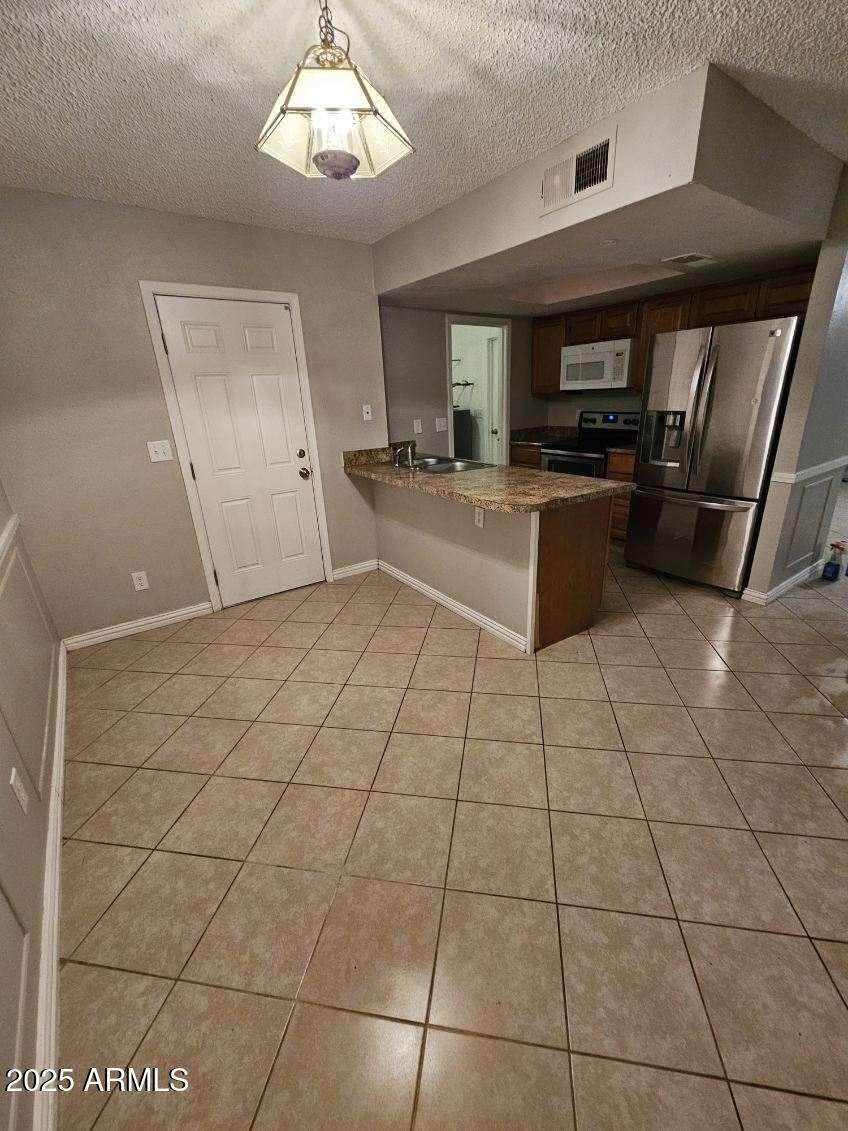 14900 South Capistrano Road Arizona City, AZ 85123 - Photo 6 of 24 a large kitchen with a stove a microwave and a counter top space