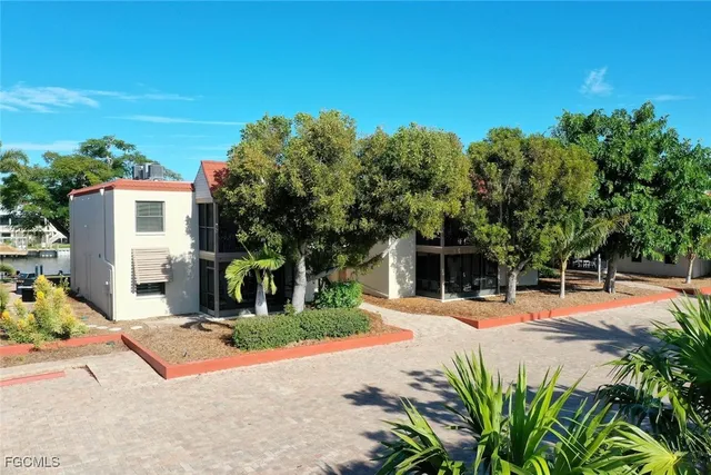 a front view of a house with a yard and potted plants