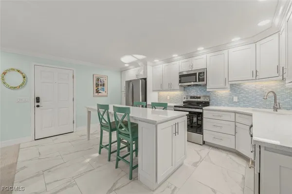a kitchen with cabinets and chairs