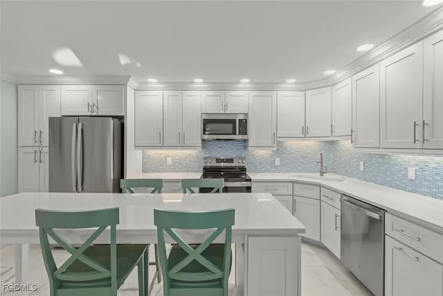 a kitchen with a sink a microwave a stove and cabinets