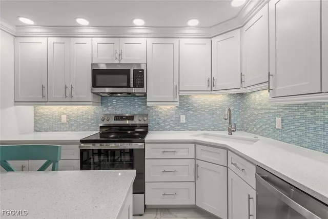 a kitchen with appliances a sink and cabinets