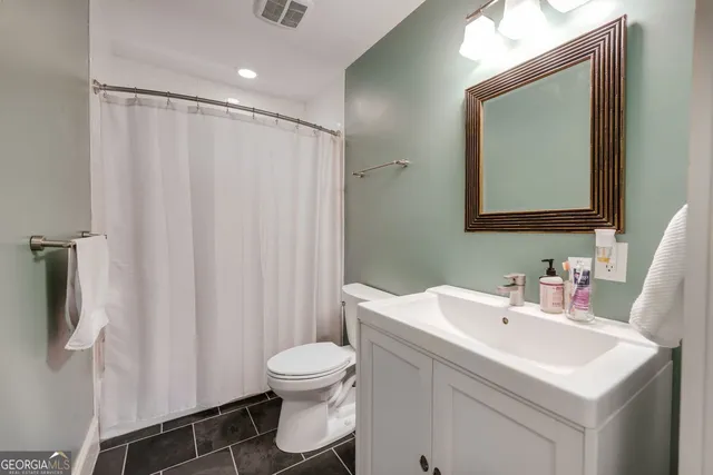 a bathroom with a sink a toilet and a mirror