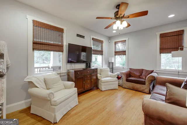 a living room with furniture flat screen tv and window