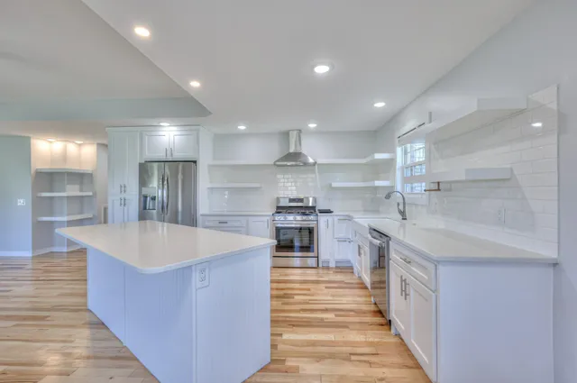 a large kitchen with stainless steel appliances kitchen island a large counter top and a sink