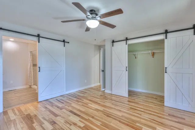 a view of a big room with wooden floor and a ceiling fan