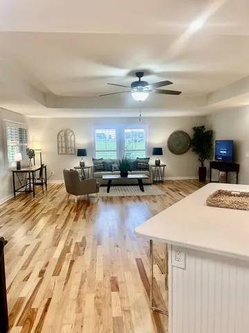 a living room with lots of furniture and kitchen view